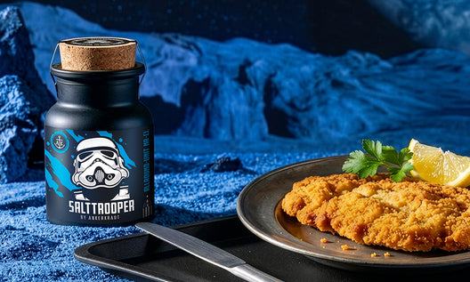 Knuspriges paniertes Schnitzel mit Zitrone auf Teller, daneben Salttrooper-Gewürz, inszeniert in blauer, futuristischer Umgebung.
